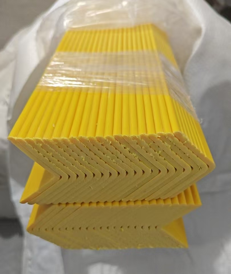 Yellow rigid PVC cover profiles stacked after extrusion production