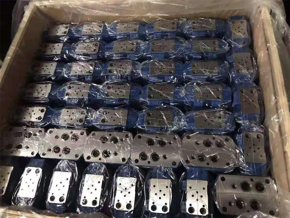 Batch of machined and painted hydraulic valve bodies packed and ready for shipment